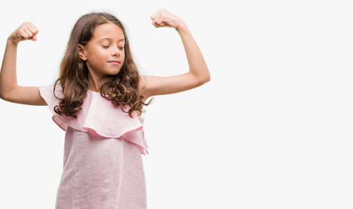 身穿粉红色连衣裙的黑发西班牙裔女孩, 显示手臂肌肉微笑自豪。健身理念
