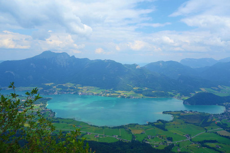 湖叫岗湖在奥地利与山在背景和云彩在天空和草在前面, 欧洲