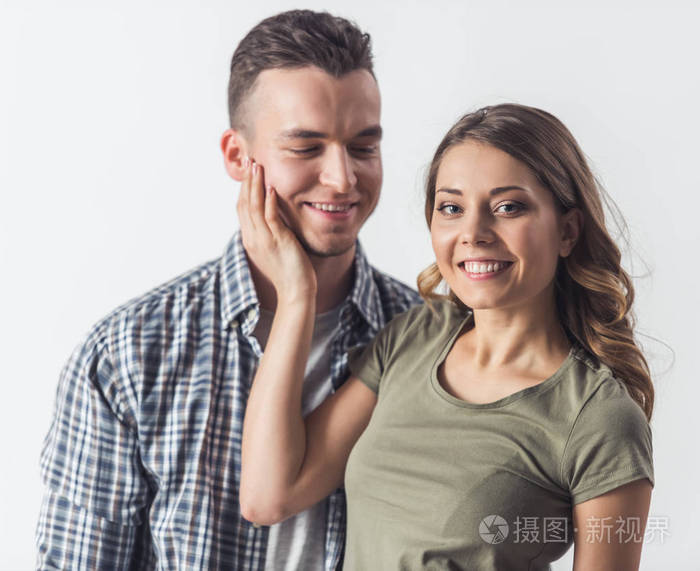 女孩抚摸着她男朋友的脸颊, 看着相机, 都在微笑.