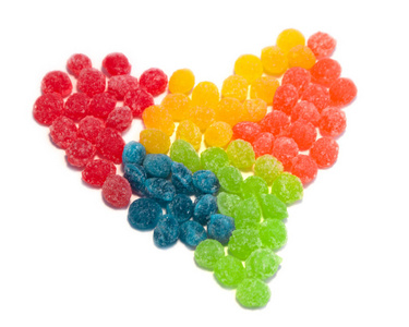 彩色糖果衬里在一个孤立的白色背景的心脏形状