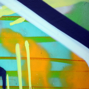 街头艺术。彩色涂鸦画片断的背景图片在卡其色的绿色和橙色口气