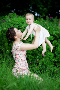 在绿色的草坪和妈妈的小漂亮宝宝
