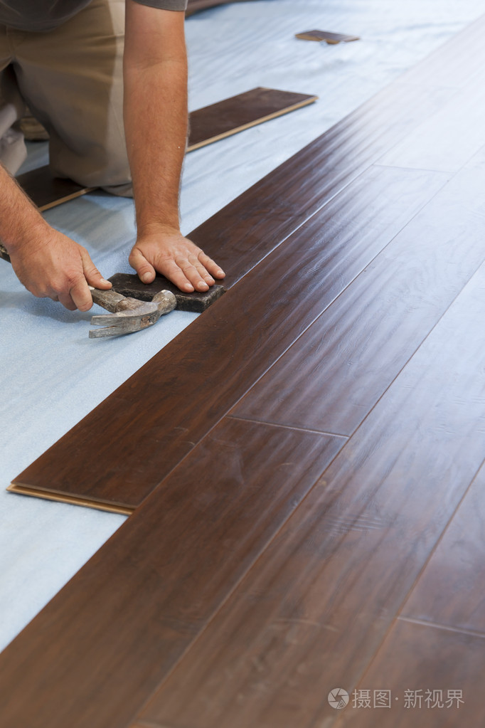 安装新的强化木地板的男人