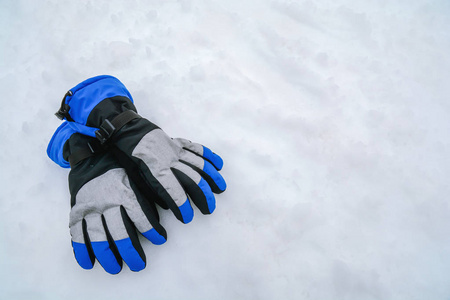 蓝色和灰色现代滑雪手套在山白色雪