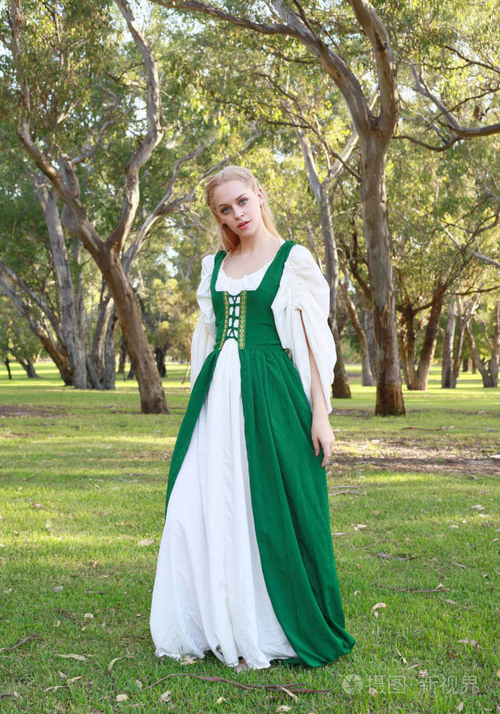 身穿绿色中世纪长袍的金发女郎全长画像, 在森林中游荡