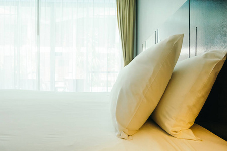 白色舒适枕头在床上装饰在旅馆床房间里