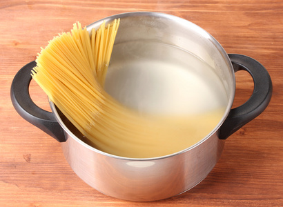 厨师在平底锅上木制背景特写 spagetti