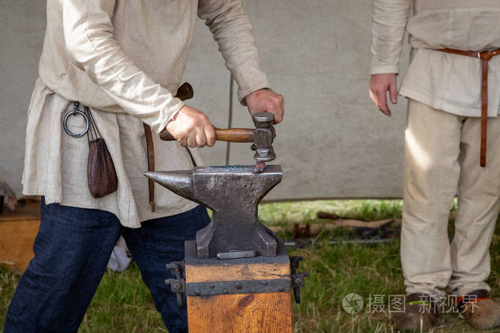 中世纪铁匠在铁砧上锻造铁