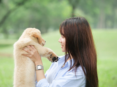 在公园玩小狗的亚洲妇女