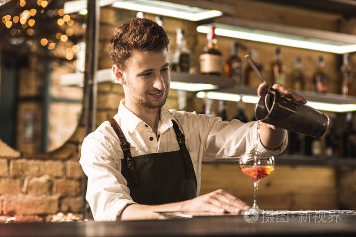 英俊的年轻酒保做鸡尾酒