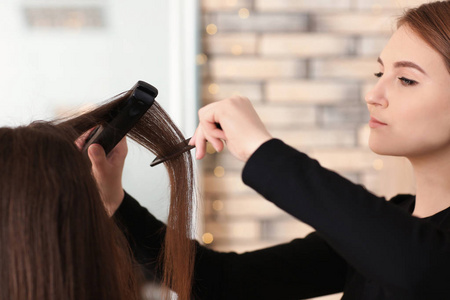 专业理发师矫直客户的头发在沙龙