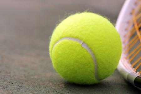 新黄色彩色的网球球放在 racketracquet 上
