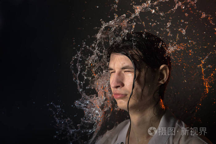 在湿衣服和溅水的迷人的年轻男子的肖像工作室照片拍摄