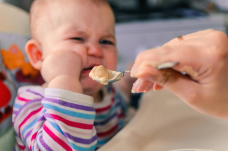 母亲给婴儿食品从一个勺子