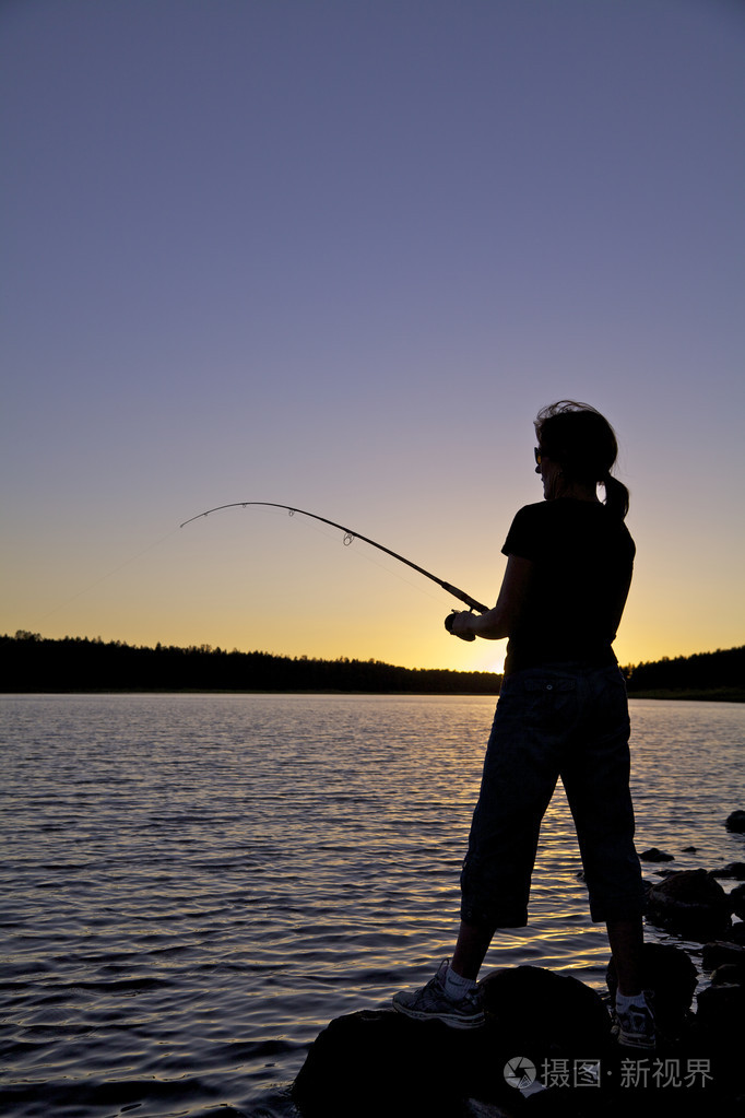 日落黄昏钓鱼的女人