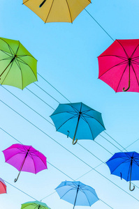 五颜六色的雨伞背景在天空中。街道装饰