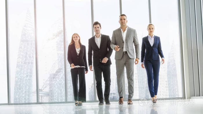 精明的商务人士步行在走廊办公室与装配玻璃背景和现代建筑.