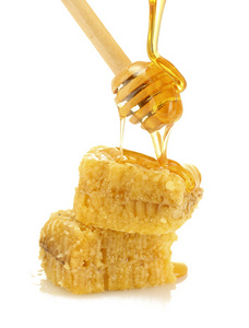 金黄的蜂窝和蜂蜜隔离在白色木制 drizzler