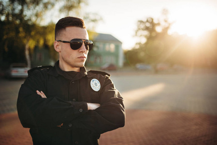 穿着制服和墨镜的严肃的男警察.警官在工作.