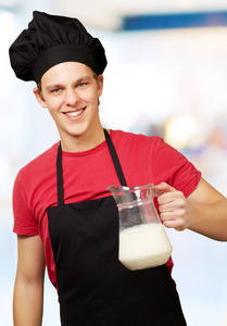 年轻厨师该名男子手持奶罐室内的肖像