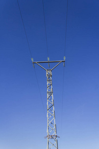 高电压塔以三根缆绳和蓝天作为背景