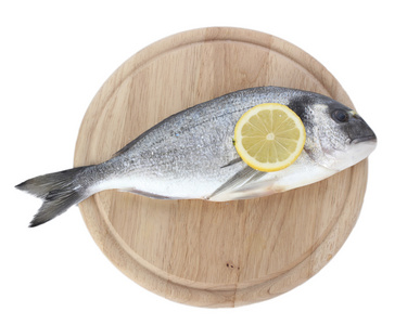 新鲜的鱼，用柠檬上木菜板上白色隔离