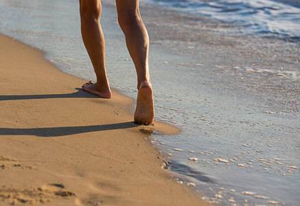 日落时分在海滩漫步的女子