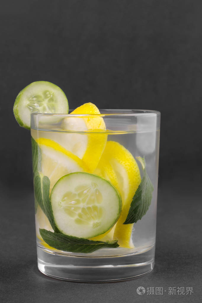 用柠檬黄瓜和薄荷在黑色背景玻璃杯中清爽水