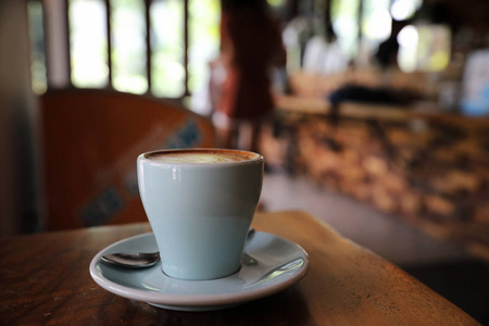 咖啡店木桌上的牛奶制成的卡布奇诺或拿铁咖啡