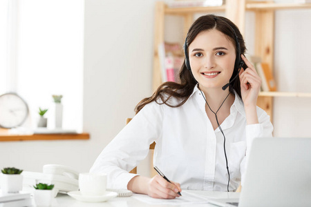 呼叫中心理念 笑脸微笑女性客户支持电话接线员工作场所