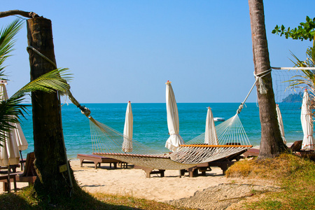 与一些树木和吊床好热带空沙滩的视图。泰国