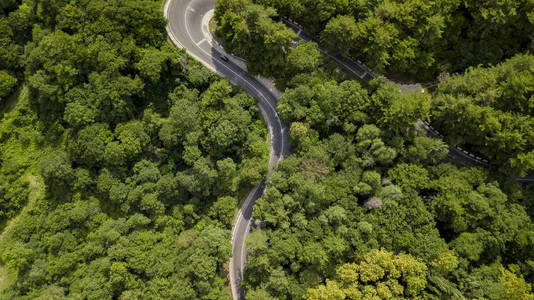 在俄罗斯索契的森林里, 沿着蜿蜒的山路行驶的汽车的空中股票照片。人行, 路之旅, 穿越美丽的乡村风光