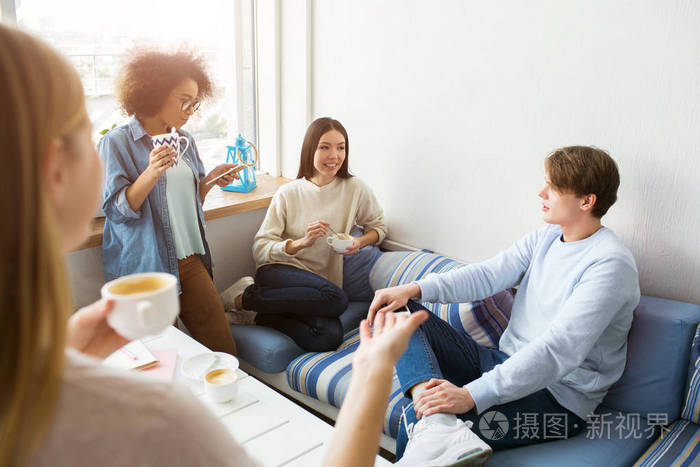 他们在聊天, 玩得很开心.学生们休息一下.美国黑人女孩正在看她的电话