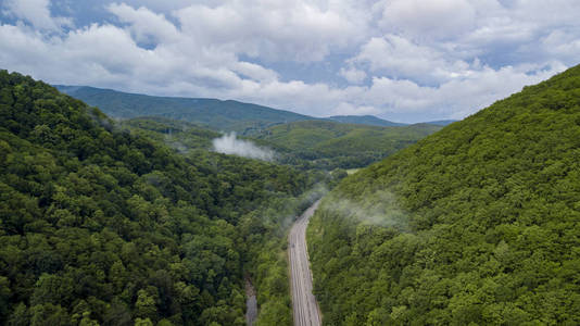 在俄罗斯索契的森林里, 沿着蜿蜒的山路行驶的汽车的空中股票照片。人行, 路之旅, 穿越美丽的乡村风光