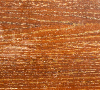 破旧的橙色木表面与剥落清漆和许多划痕