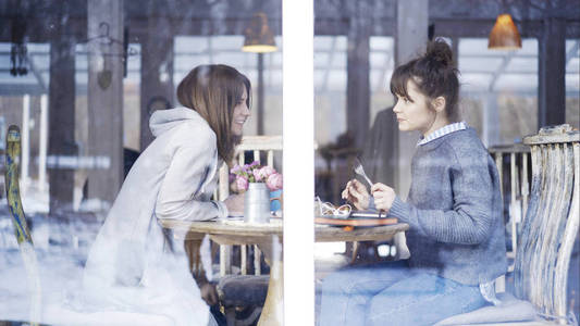 两个女朋友在咖啡馆里见面聊天