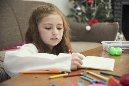 小女孩画一张五颜六色的图片用铅笔蜡笔在桌室内