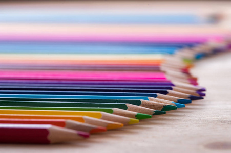 在木桌上的一组鲜艳的彩色铅笔。锐蜡笔背景。场浅景深