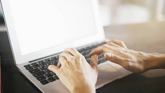 女性手上的铝笔记本电脑键盘打字