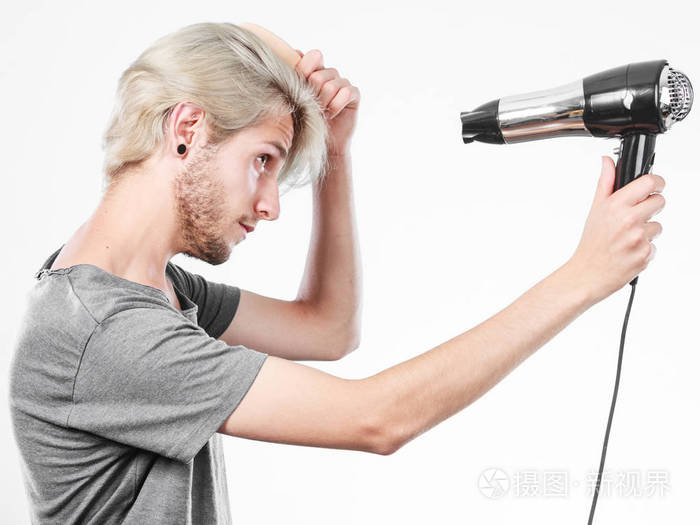 金发碧眼的人抓着头发吹风机和梳子创建新发型