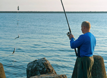 一个男人钓上一条鱼, 钓上一只鱼竿, 在萨拉克钓鱼, 晚上钓鱼, 在春天出海钓鱼。