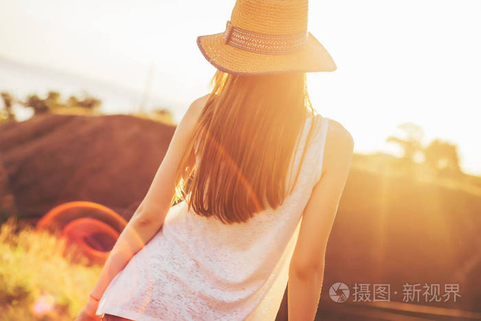 温暖的夏日傍晚.女孩和太阳的光芒