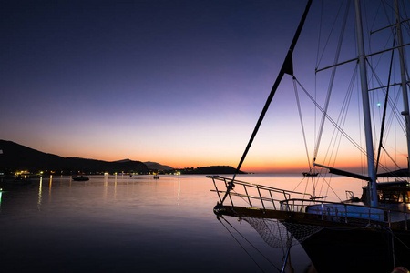 小船头看法在美丽的暮光日落和紫色的天空在海在码头