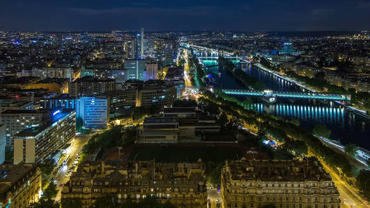鸟瞰巴黎市和塞纳河河晚上间隔拍摄拍摄在埃菲尔铁塔观景台。晚上的照明。关于道路交通