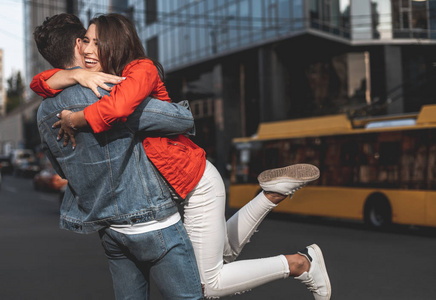满长的快乐女人和男人拥抱彼此的喜悦的侧面视图.