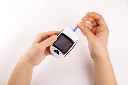 一人糖尿病做血液测试与嘉隔离的白色背景
