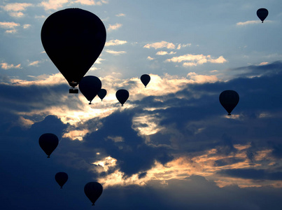 许多乘客气球在云彩的黎明背景下飞行