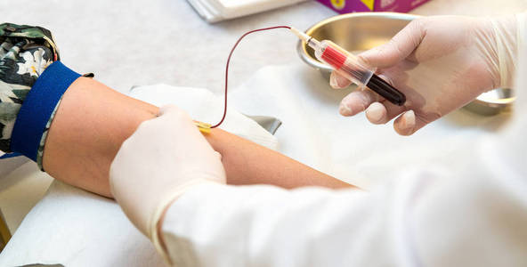 医生手紧贴女性静脉穿刺采血近距离护士穿刺针注射器给静脉病人抽血