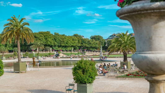 在巴黎，法国的喷泉与游戏卢森堡花园中时光倒流这美丽的景色。蓝多云的天空，在夏季的一天