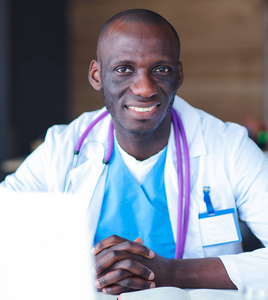 年轻的非洲医生在台笔记本电脑上工作。医生。工作场所